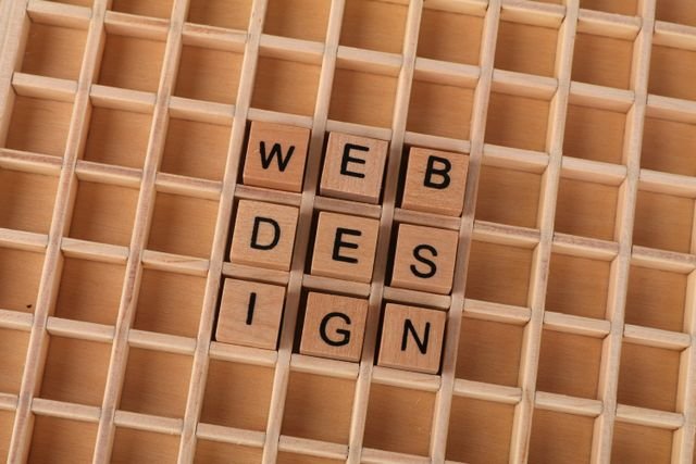 Wooden blocks spelling web design on a grid background symbolizing creative digital design concepts.